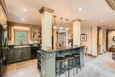 a large kitchen with a large island with stools at Keystone Gulch Estate 1688 estate in Keystone