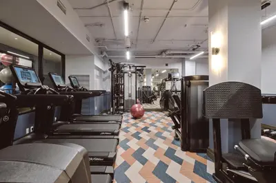 a gym with treadmills and elliptical machines at Clayton Hotel & Members Club in Denver
