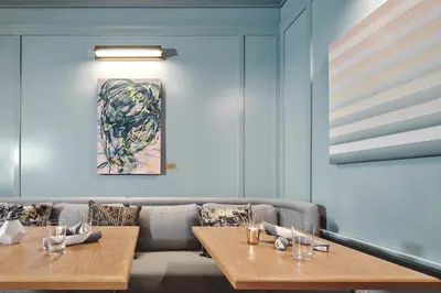 a dining room with two tables and a couch at Clayton Hotel & Members Club in Denver