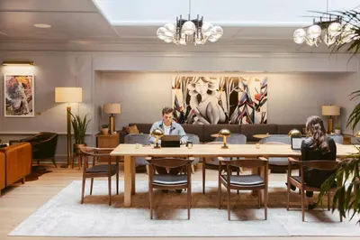 a man sitting at a table with a laptop at Clayton Hotel & Members Club in Denver
