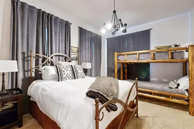 a bedroom with a bed and a wooden bunk bed at Base Camp 496 in Winter Park