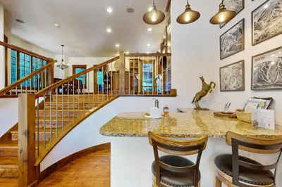 a room with a staircase and a table and chairs at Base Camp 496 in Winter Park