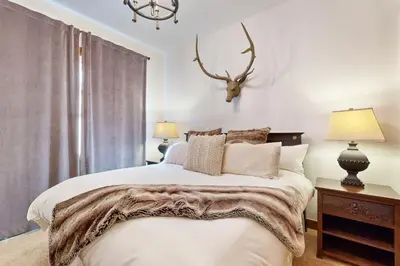 a bedroom with a bed with a deer head on the wall at Base Camp 496 in Winter Park