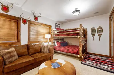 a living room with a couch and a bunk bed at Base Camp 496 in Winter Park