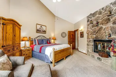 a bedroom with a bed and a stone fireplace at Winter Park Place 14 in Winter Park