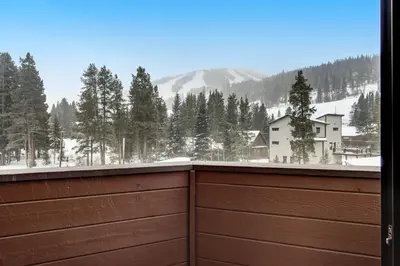 a view of a snowy mountain from a wooden fence at Winter Park Place 14 in Winter Park