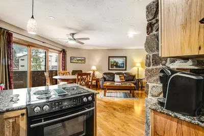 a kitchen with a stove and a living room at Winter Park Place 14 in Winter Park