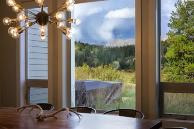 a dining room with a table and a large window at Willows at Grand Park home in Fraser