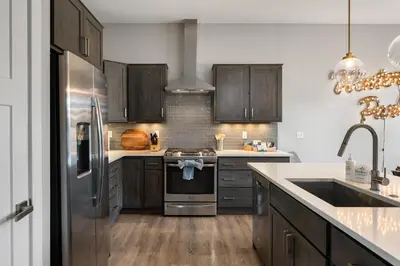 a kitchen with wooden cabinets and a stainless steel refrigerator at Willows at Grand Park home in Fraser