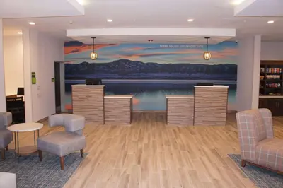 a lobby with a large painting on the wall at La Quinta Inn & Suites by Wyndham Littleton-Red Rocks in Littleton