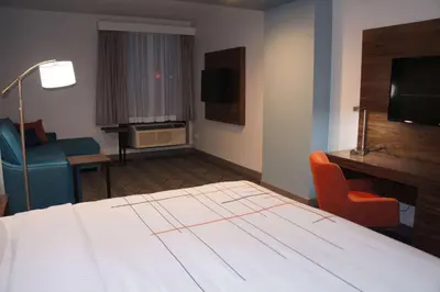 a hotel room with a bed and a desk and chair at La Quinta Inn & Suites by Wyndham Littleton-Red Rocks in Littleton