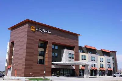 a hotel building with a sun sign on it at La Quinta Inn & Suites by Wyndham Littleton-Red Rocks in Littleton