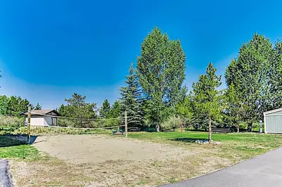 a yard with a volleyball net and trees at Twin Rivers 3 in Fraser