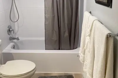 a white bathroom with a toilet and a shower at Twin Rivers 3 in Fraser