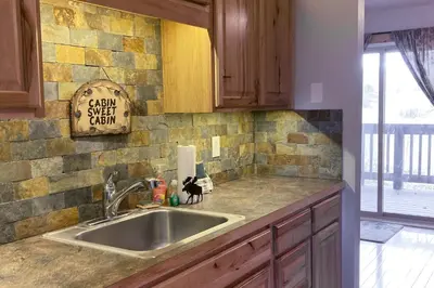 a kitchen with a sink and a stone wall at Twin Rivers 3 in Fraser