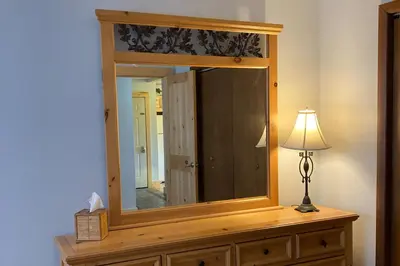 a mirror on top of a dresser with a lamp at Twin Rivers 3 in Fraser