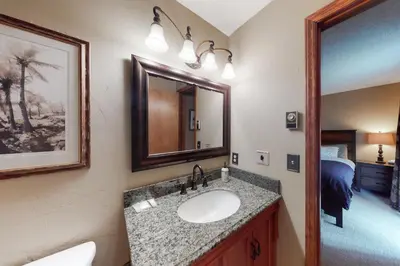a bathroom with a sink and a mirror and a bed at Timber Run Evergreen 9 in Winter Park