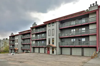 an apartment building with balconies and a car parked in front at Timber Run Evergreen 9 in Winter Park