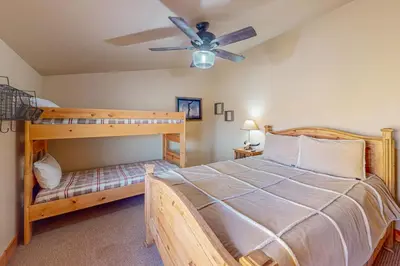 a bedroom with two bunk beds and a ceiling fan at Spruce Chalet in Granby