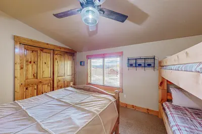 a bedroom with a bed and a ceiling fan at Spruce Chalet in Granby