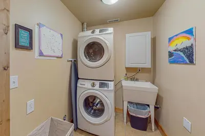 a laundry room with a washing machine and a sink at Spruce Chalet in Granby