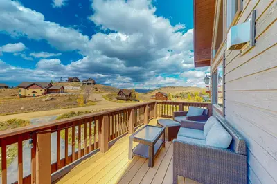 a balcony with chairs and a view of the mountains at Spruce Chalet in Granby