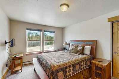 a bedroom with a bed and two windows at Arrowhead 31 in Fraser