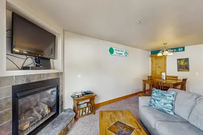 a living room with a fireplace and a flat screen tv at Arrowhead 31 in Fraser