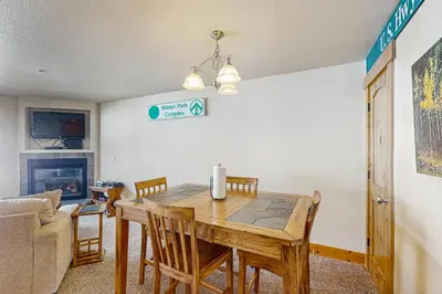 a dining room with a table and chairs and a couch at Arrowhead 31 in Fraser