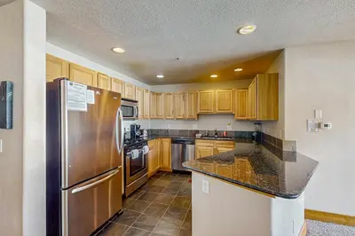 a kitchen with wooden cabinets and a stainless steel refrigerator at Arrowhead 31 in Fraser