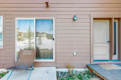 a chair sitting outside of a house with a window at Arrowhead 31 in Fraser