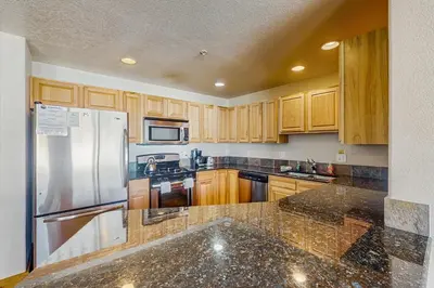 a kitchen with wooden cabinets and a stainless steel refrigerator at Arrowhead 31 in Fraser