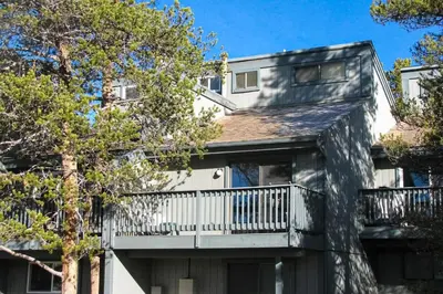 a large house with a balcony and trees at MeadowRidge 13-04 in Fraser