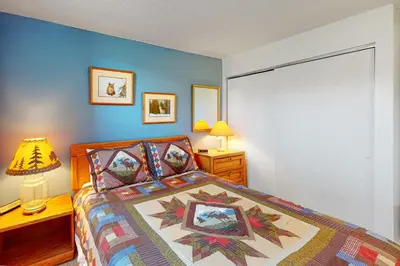 a bedroom with a bed with a quilt on it at MeadowRidge 13-04 in Fraser