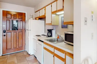 a kitchen with a white refrigerator and a sink at Timber Run Vista 2 in Winter Park