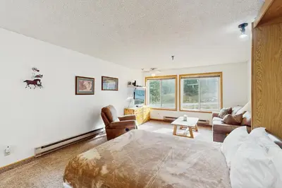 a bedroom with a bed and a living room at Snowblaze Condominiums E103 in Winter Park