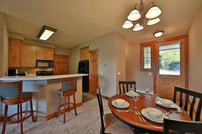 a kitchen and dining room with a table and chairs at Kicking Horse Lodges 3-202 in Granby