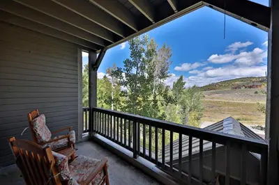 a balcony with two chairs and a view of a field at Kicking Horse Lodges 3-202 in Granby