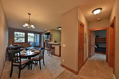 a dining room and living room with a table and chairs at Kicking Horse Lodges 3-202 in Granby