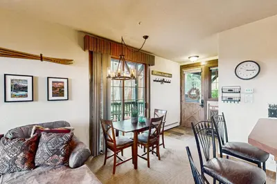 a living room with a table and a dining room at Kicking Horse Lodges 4-205 in Granby