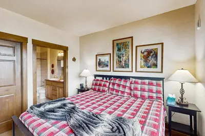 a bedroom with a bed with a red and white blanket at Kicking Horse Lodges 4-205 in Granby
