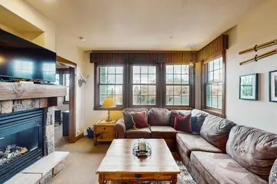 a living room with a couch and a fireplace at Kicking Horse Lodges 4-205 in Granby