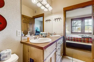 a bathroom with a sink and a toilet and a mirror at Kicking Horse Lodges 4-205 in Granby