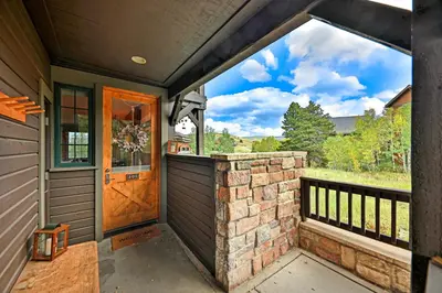 a porch with a wooden door and a balcony at Kicking Horse Lodges 4-205 in Granby