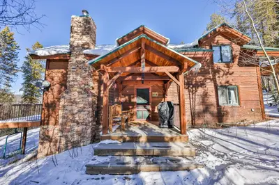 a log cabin in the snow with a chimney at Sunset Chalet in Tabernash