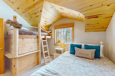 a bedroom with a bunk bed and a ladder at Sunset Chalet in Tabernash