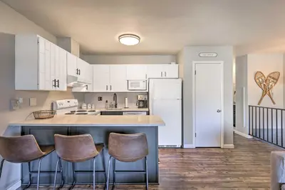 a kitchen with white cabinets and a large island with bar stools at 7 Mi to Keystone Mtn-View Abode with Deck! in Dillon