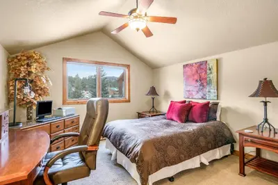 a bedroom with a bed and a desk with a computer at Tranquility On The River Three -- EV #6042 townhouse in Estes Park