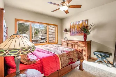 a bedroom with a bed and a desk and a window at Tranquility On The River Three -- EV #6042 townhouse in Estes Park
