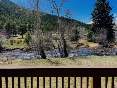 a view of a river from a wooden bench at Tranquility On The River Four -- EV #6041 townhouse in Estes Park